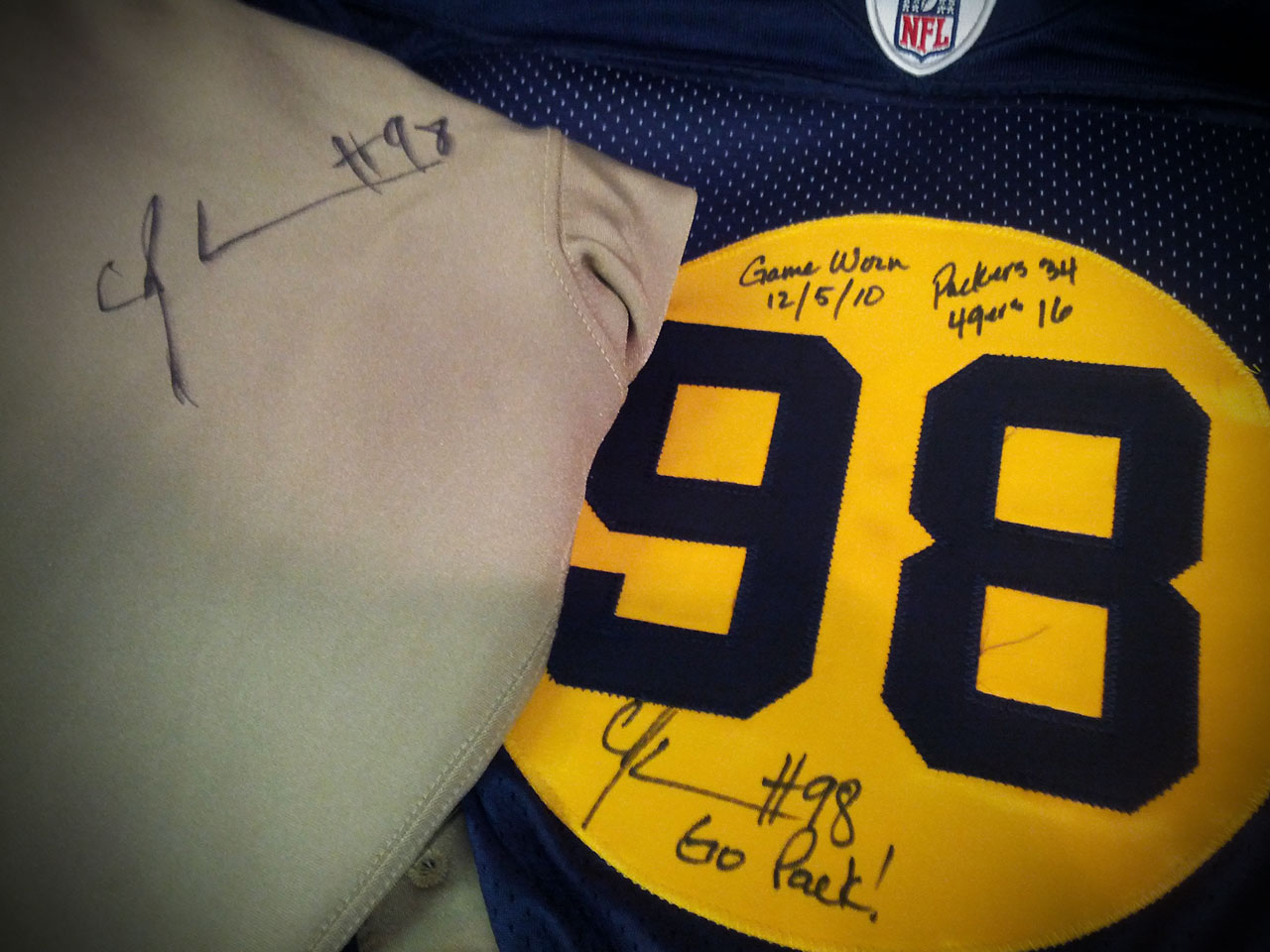 Inscribed with game score, "Game Worn 12/5/10", and signed "Go Pack" by C.J. Wilson (#98)